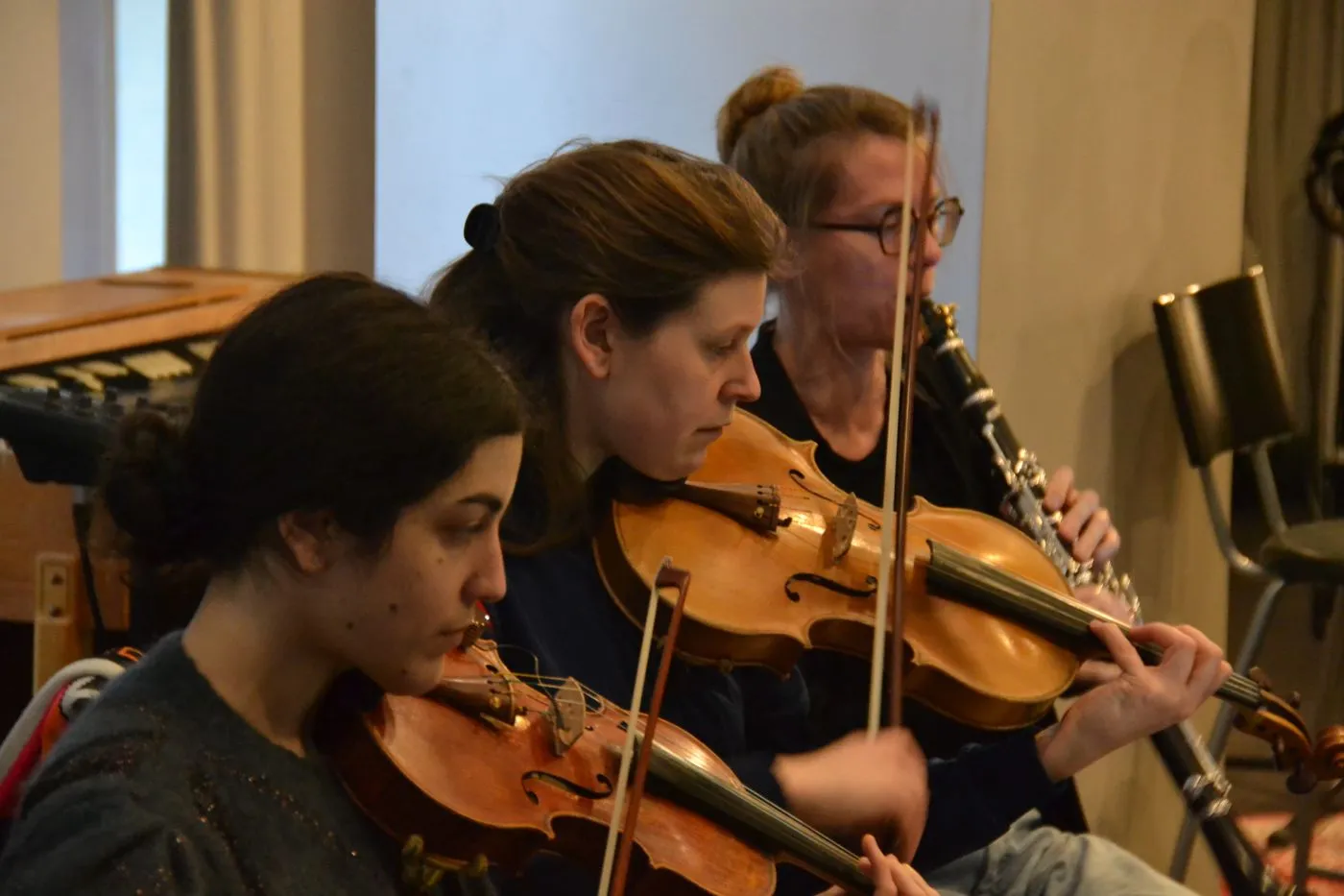 Two violinists and a clarinettist during a session